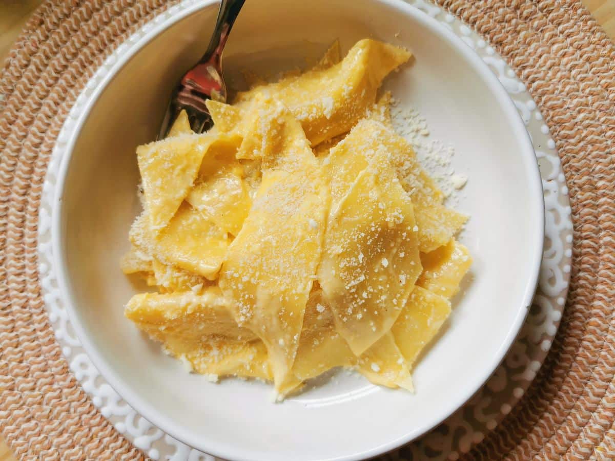 Pasta with mascarpone in white bowl.